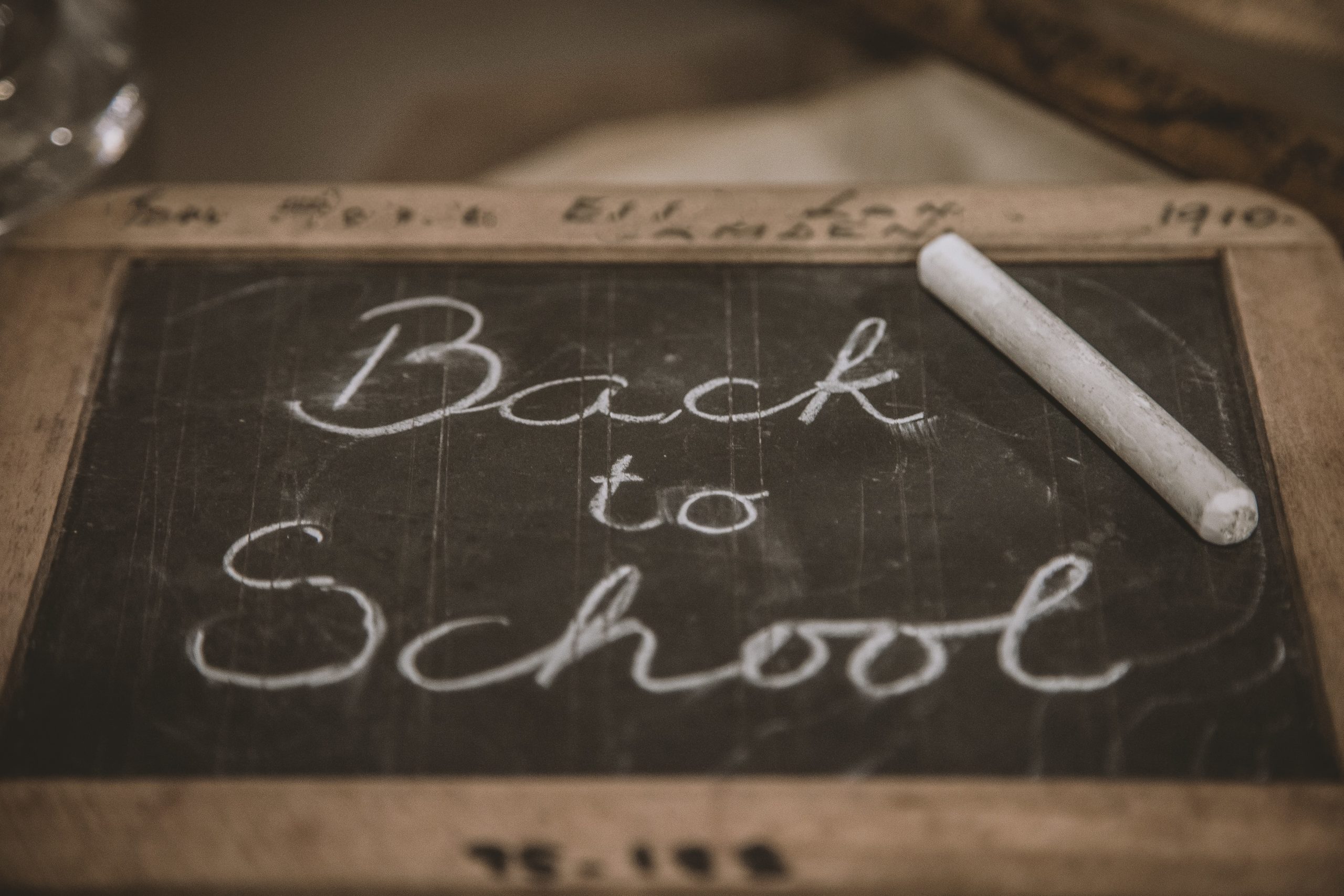 NSITE offers accessible courses, ready for Back to School. Photo of a small wooden chalkboard with white chalk spelling out in cursive Back to School. Photo by Deleece Cook on Unsplash