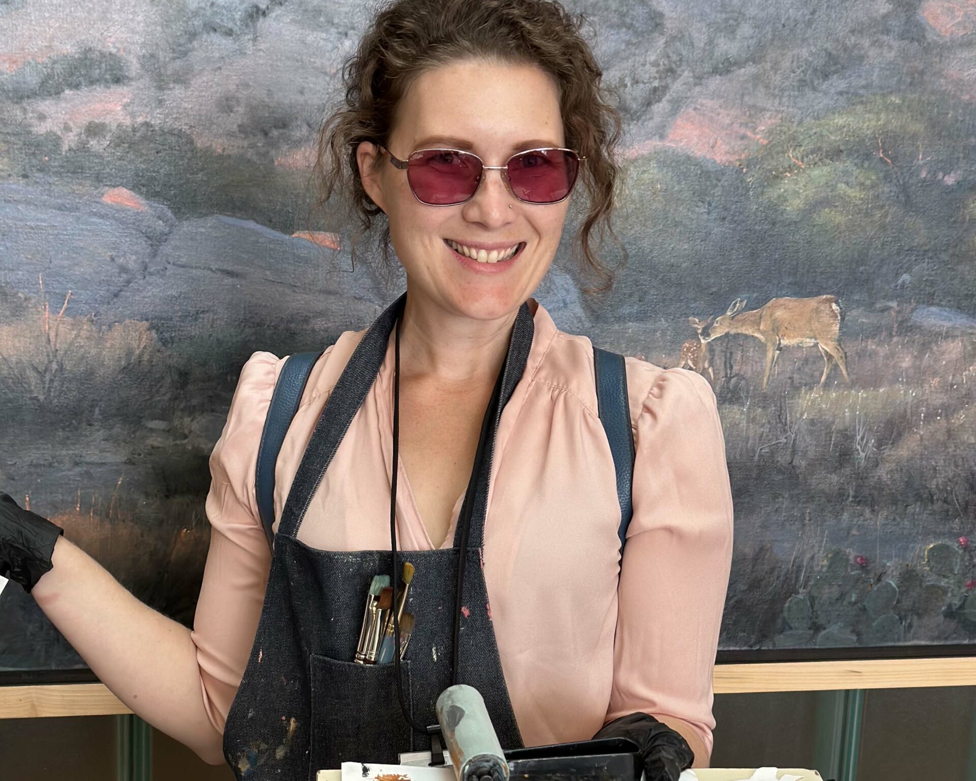 Artist Heather Bergerson smiles and holds a paint palette