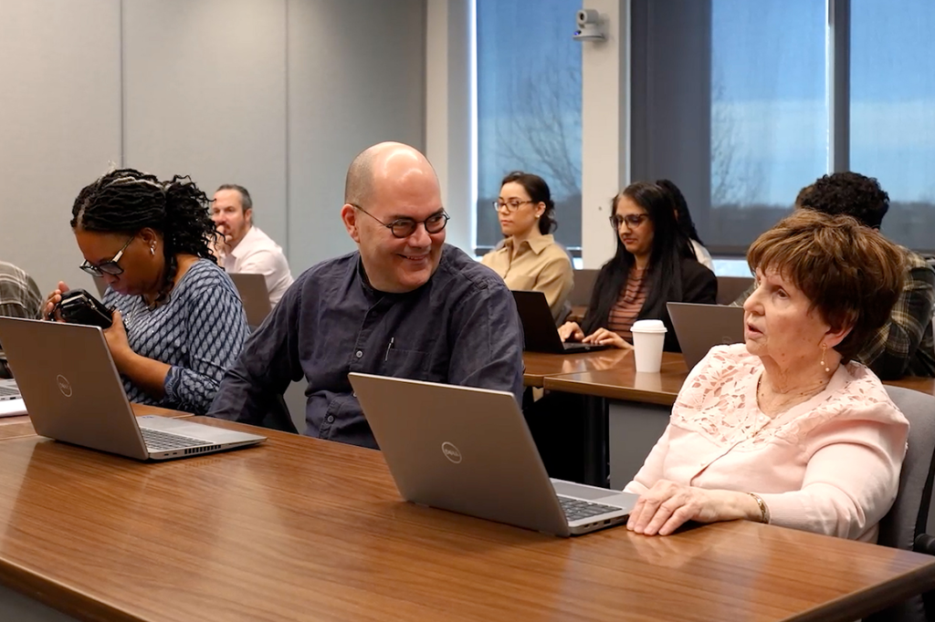 mage of training participants sitting together with laptops.