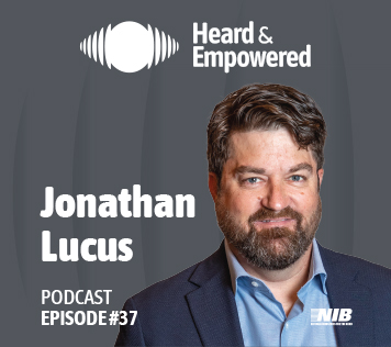 A man is pictured in front of a gray background.